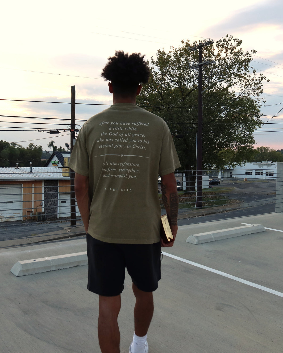 RESTORE tee worn, back verse at sunset